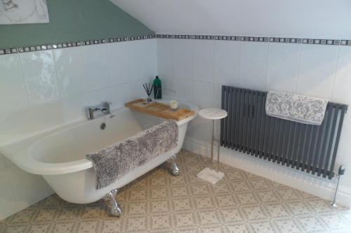 a bathroom with a bath tub and a sink at The Swainson Suite in Windermere