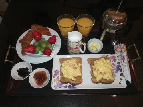 a table with a tray of breakfast foods and drinks at The Swainson Suite in Windermere