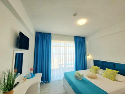 ein großes Schlafzimmer mit blauen Vorhängen und einem großen Bett in der Unterkunft Vila Thassos Sea View pe plaja Belona in Eforie Nord