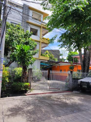 Terrazas de Miguel Apartment في Iriga City: سور أبيض أمام مبنى