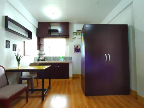 una cocina con una gran nevera negra y una mesa en Terrazas de Miguel Apartment, en Iriga City