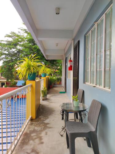 een patio met een tafel en stoelen op een balkon bij Terrazas de Miguel Apartment in Iriga City