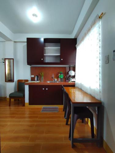 cocina con mesa de madera y comedor en Terrazas de Miguel Apartment, en Iriga City