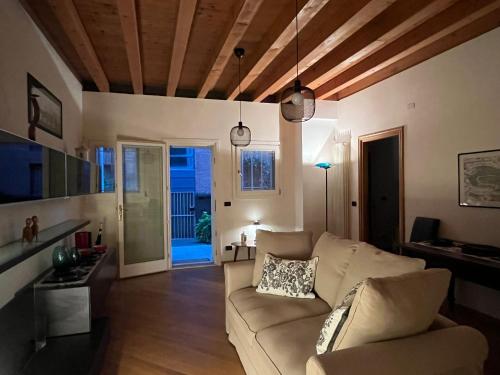 ein Wohnzimmer mit einem Sofa und einem Tisch in der Unterkunft Venezia,Giudecca appartamento con giardino privato in Venedig
