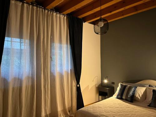 1 dormitorio con cama y ventana grande en Venezia,Giudecca appartamento con giardino privato en Venecia