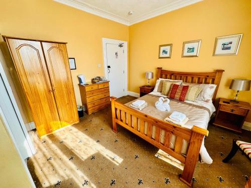 a bedroom with a wooden bed and a dresser at Perfect for large groups! in Torquay