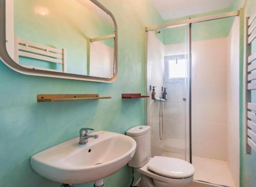 ein Badezimmer mit einem Waschbecken, einem WC und einem Spiegel in der Unterkunft Casa Turqueta in Maó