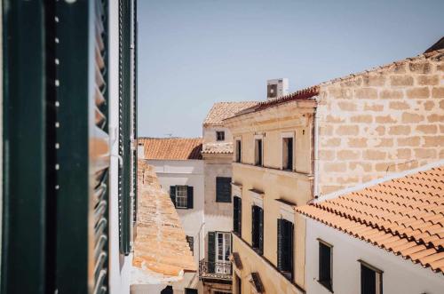 a view of an alley between buildings with roofs at Casa Turqueta in Mahón