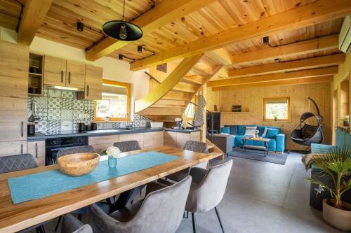 a kitchen and living room with a wooden ceiling at A Nest Under the Karawanks in Žirovnica