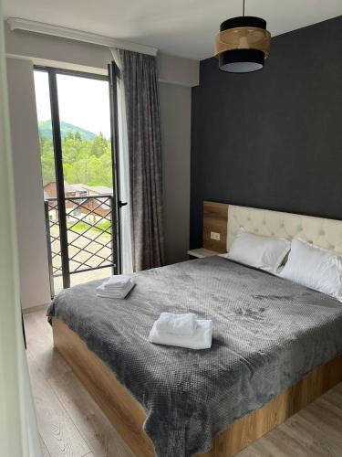 a bedroom with a bed with two towels on it at Bakuriani Hotel Apartments 301 in Bakuriani