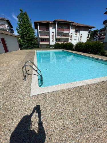 une ombre d'une personne prenant une photo d'une piscine dans l'établissement itsasoa Golf et Mer, à Ciboure