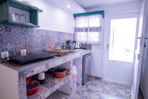 a kitchen with a sink and a window at Ta Kymata Karpathos in Karpathos Town