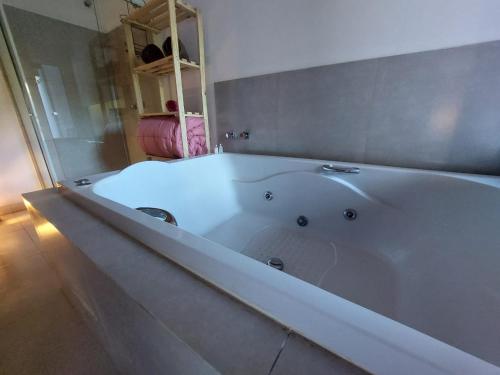 a large white bath tub in a bathroom at Recanto da Floresta Suítes in Petrópolis