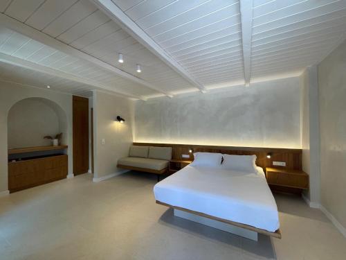 a bedroom with a white bed and a chair at Melitsina Village Hotel in Kardamili