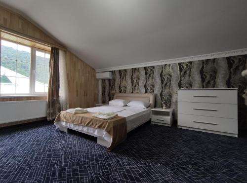 a bedroom with a bed and a dresser and a window at Voyage Gabala in Gabala