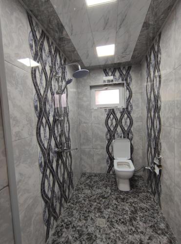 a bathroom with a toilet with a black and white patterned wall at Voyage Gabala in Gabala
