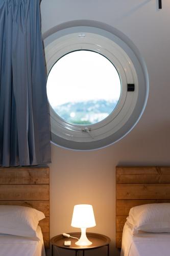 a room with two beds and a round window at LPH - Dannunziano Country House in Chieti