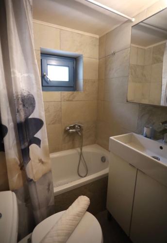 a bathroom with a toilet and a sink and a tub at Hytra view house in Kythira