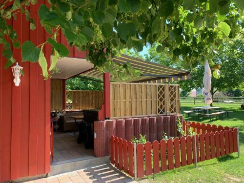 a red house with a fence and a table at Ferienhaus Spielburg in Altötting