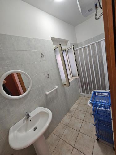 een badkamer met een wastafel en een spiegel bij Casa vacanze Leonardo in Peschici