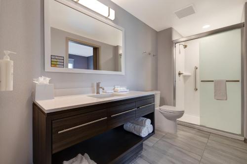 a bathroom with a sink and a toilet and a mirror at Home2 Suites By Hilton Petaluma in Petaluma