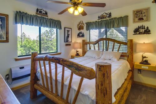 a bedroom with a wooden bed and a ceiling fan at Scenic Arizona Cabin Rental Near Show Low Lake! in Show Low