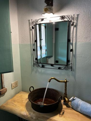 a bathroom sink with a faucet pouring water into it at Graziosa stanza campidanese Su terzu in Oristano