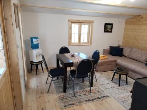 uma sala de estar com uma mesa e cadeiras e um sofá em Milica 1 em Kalna