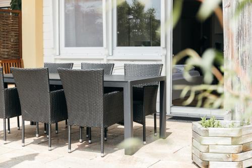 a black table and chairs on a patio at HEIMATEL - Suiten, Apartments und Studios in Scheidegg