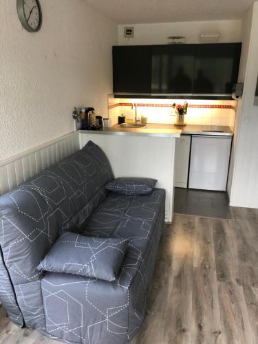 un canapé dans un salon avec une grande télévision dans l'établissement Studio à Corrençon en Vercors, à Corrençon-en-Vercors