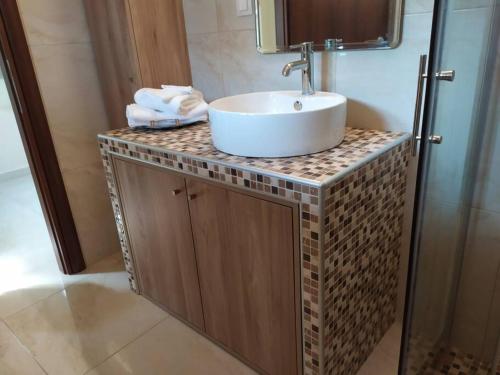 a bathroom with a white sink on a counter at Renovated apartment 300m from the sea in Ierissos