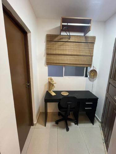 a small black desk in a room with a window at Residencial Temporada Aracaju in Aracaju