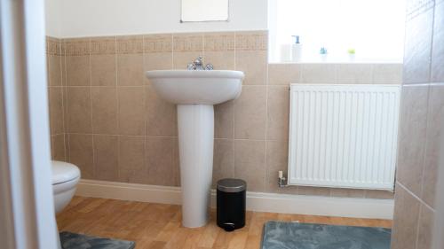 a bathroom with a sink and a toilet at Modern Marvel in Whaddon