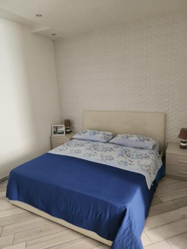 - une chambre avec un lit bleu et 2 oreillers dans l'établissement B & B VIA ROMA, à Ercolano