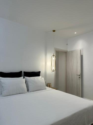 um quarto com uma cama grande e lençóis brancos em Rodanthi 4 Seasons Unique House em Tympáki