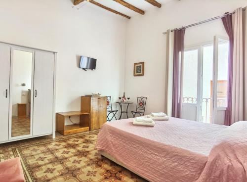 トラーパニにあるSAT Appartamenti Locazioni turistiche brevi-G&P HOLIDAY HOMEの白いベッドルーム(ベッド1台、バルコニー付)
