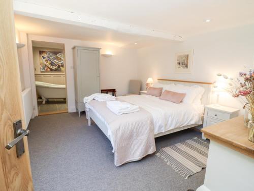 1 dormitorio con 2 camas y bañera en Spring Cottage, en Stroud