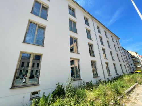 ein weißes Gebäude mit Seitenfenstern in der Unterkunft LIGHTPLACE • Design • Boxspring • Balkon • 2 Smart TV •Innenstadt in Braunschweig