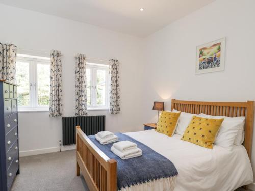 a bedroom with a bed with yellow and blue pillows at The Barn in Poole