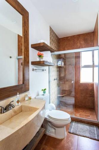 a bathroom with a toilet and a shower and a sink at Vista al Mar - Monterosa in Sayulita