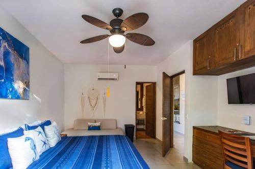 a bedroom with a bed with a ceiling fan at Vista al Mar - Monterosa in Sayulita