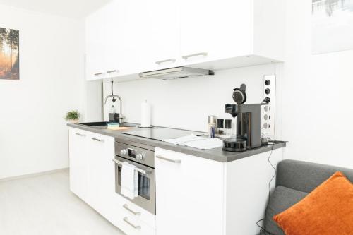 a kitchen with a counter with a coffee maker at HEIMATEL - Suiten, Apartments und Studios in Scheidegg