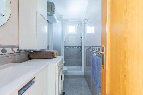 a white bathroom with a toilet and a shower at Apartamento Pobla de farnals, vistas al mar, wifi in Puebla de Farnals