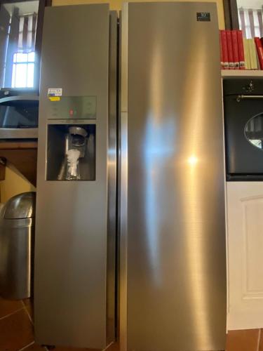 a stainless steel refrigerator in a kitchen with a picture on it at Lodge Villa Maria in Teolo