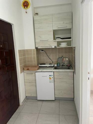 a small kitchen with a white refrigerator and cabinets at Asprovalta M in Asprovalta