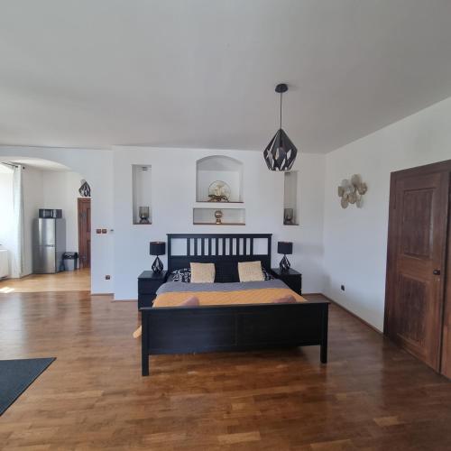 a bedroom with a bed and a wooden floor at Vila Lucia - Apartmán 4 in Plzeň