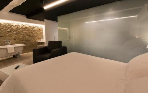 1 dormitorio con 1 cama y baño con bañera en Hotel Montes, en Santiago de Compostela