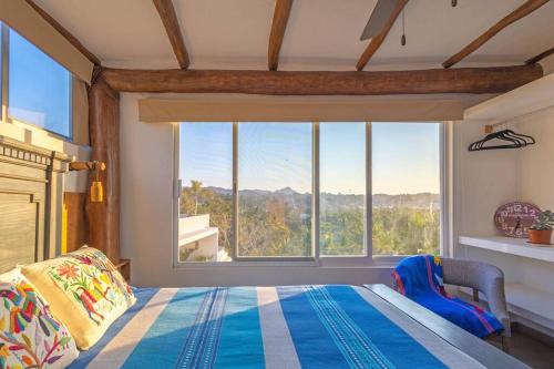 a bedroom with a bed and a large window at Skyhouse in Sayulita