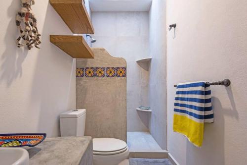 a small bathroom with a toilet and a shower at Skyhouse in Sayulita