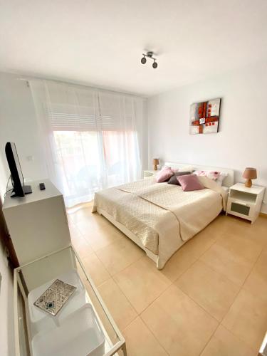 a bedroom with a bed and a television in it at ENJOY Mar Menor in Torre-Pacheco